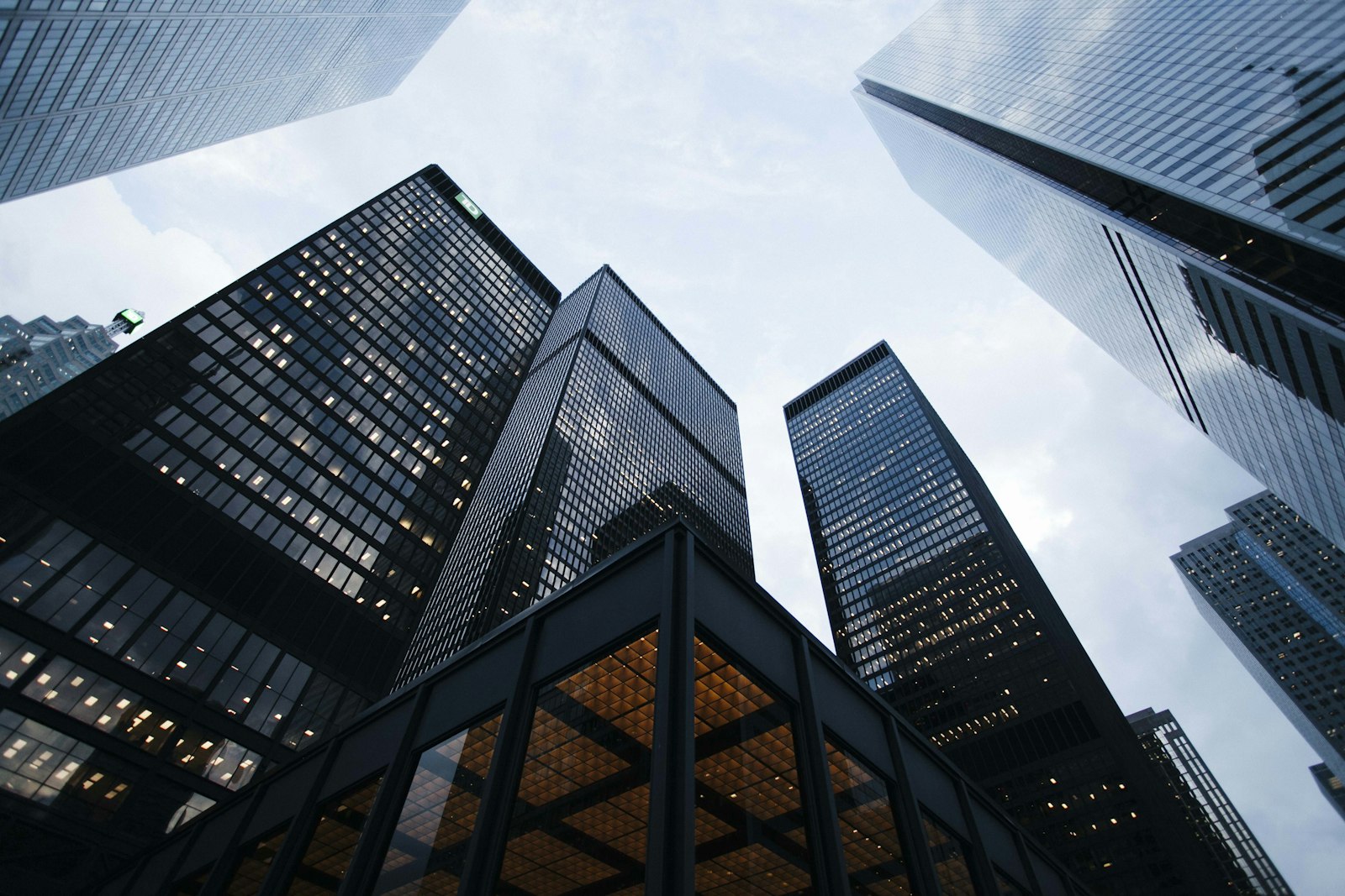 Skyscrapers photographed from street level against a pale sky. It accompanies an article about Tokens, type, and the decisions that stop visual drift.