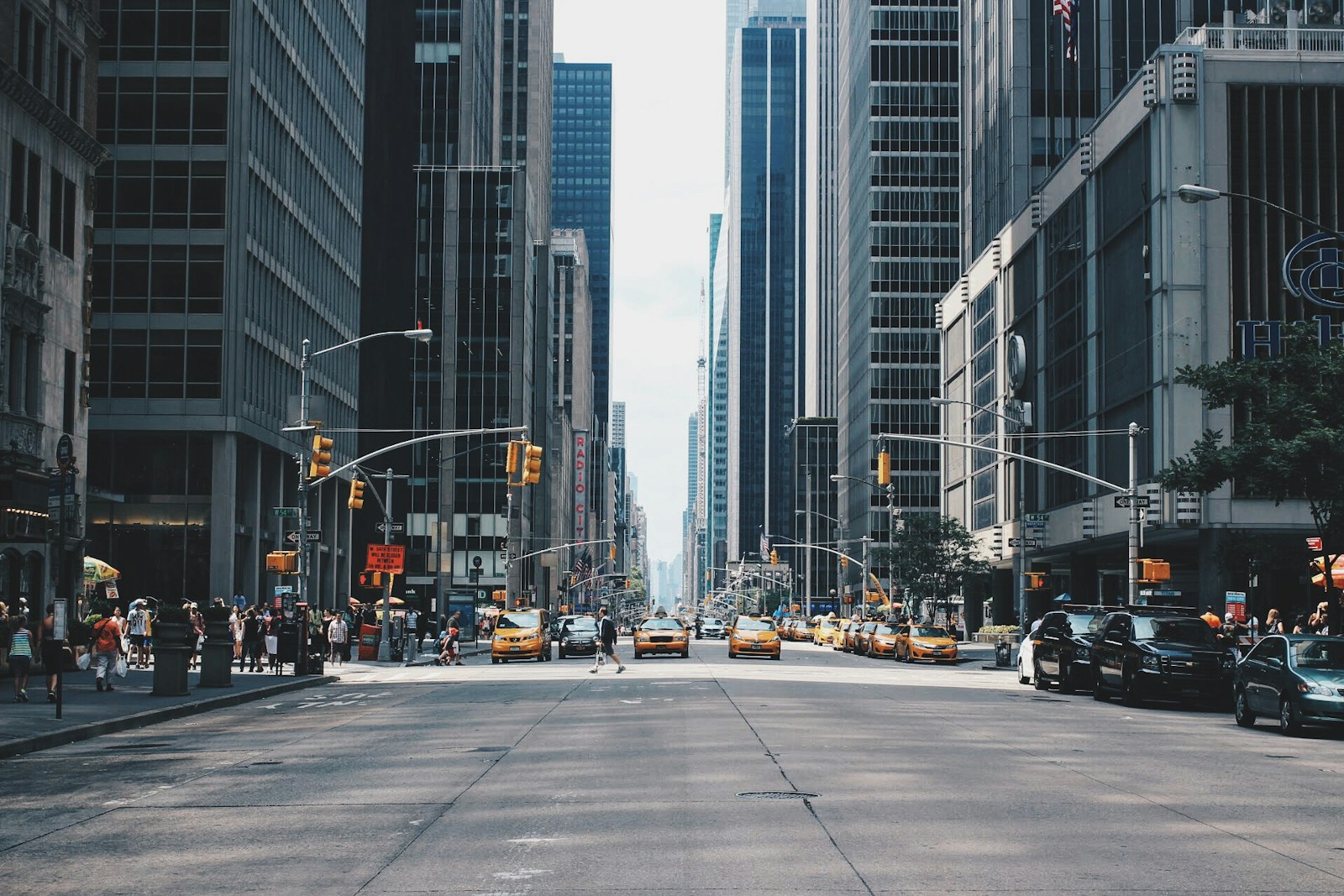 A wide city avenue with yellow taxis, tall buildings, and people on the sidewalk. It accompanies an article about Brand guidelines your engineers will actually open.