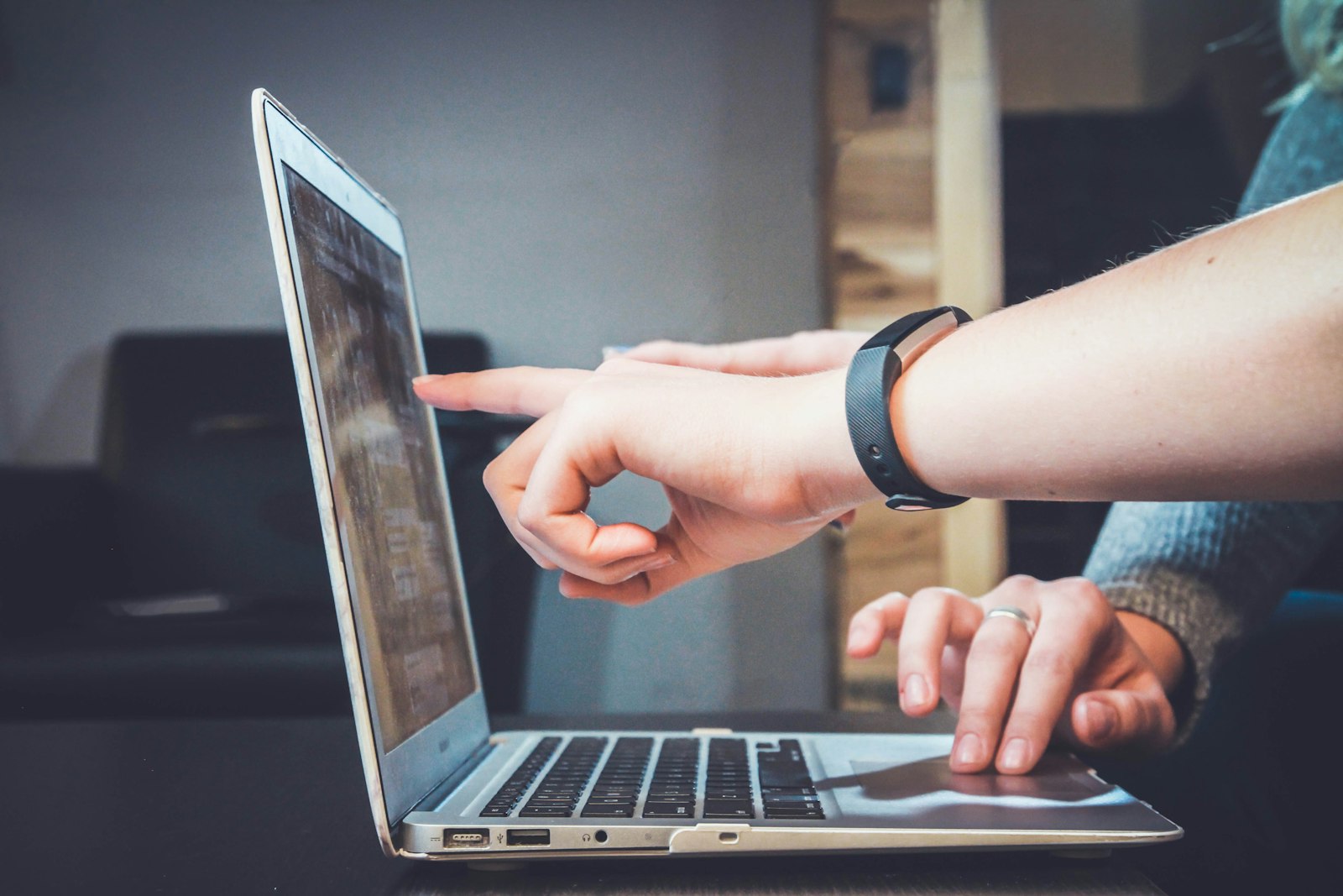 Two people pointing at a laptop screen, one wearing a fitness band. It accompanies an article about The page and the email after purchase.