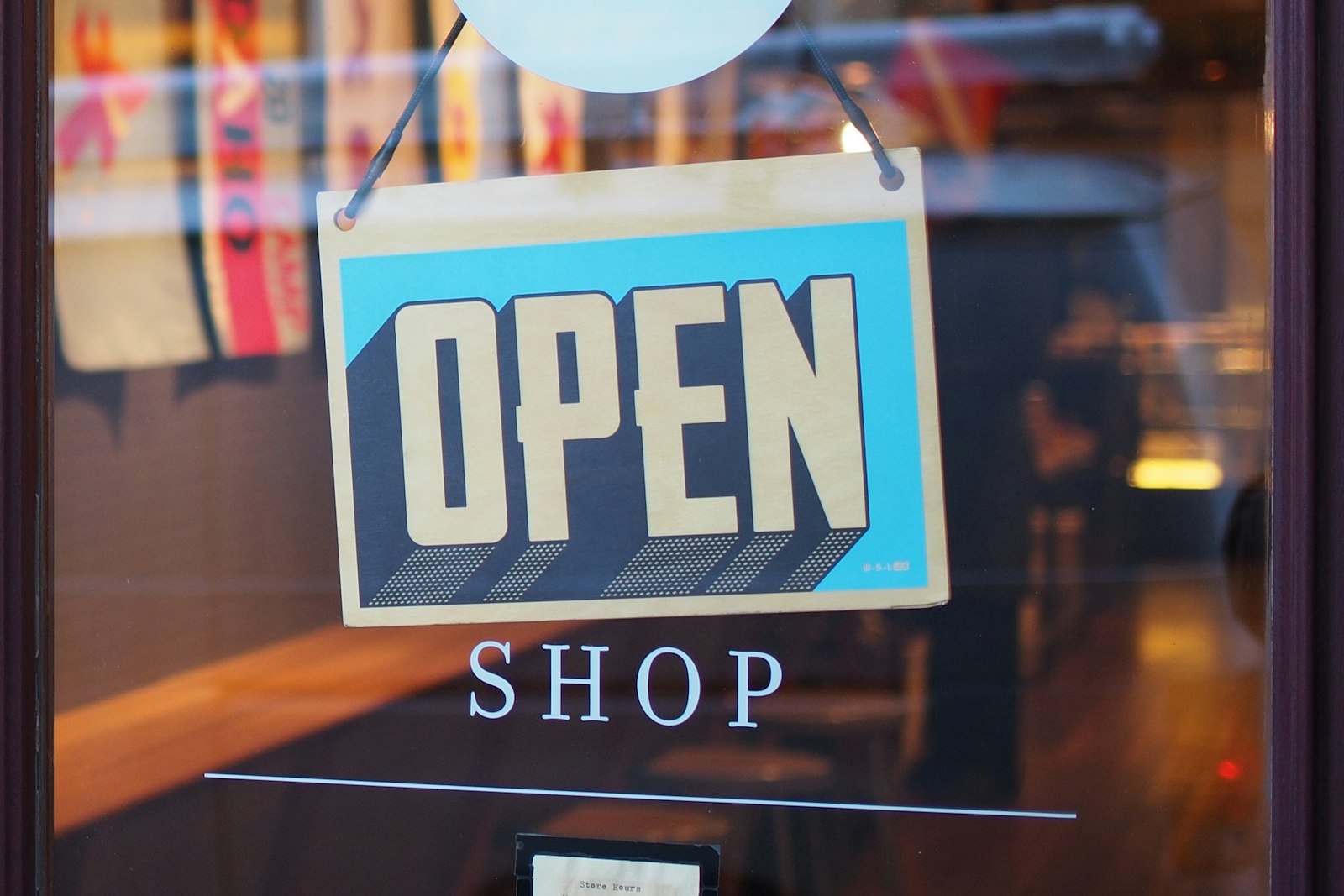 An OPEN sign hanging in a shop window, with the word SHOP printed on the glass. It accompanies an article about Staging, DNS, and the week before launch.