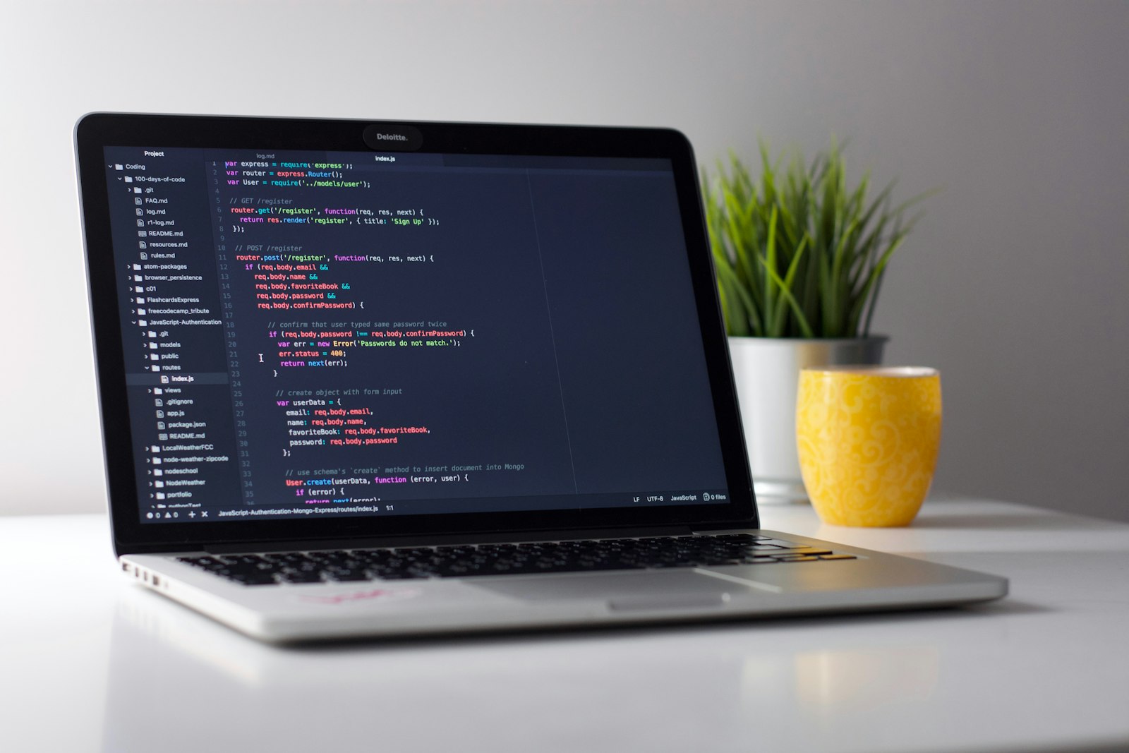 A laptop open to a code editor on a white desk, beside a plant and a yellow mug. It accompanies an article about Case-study pages that do more than show screenshots.
