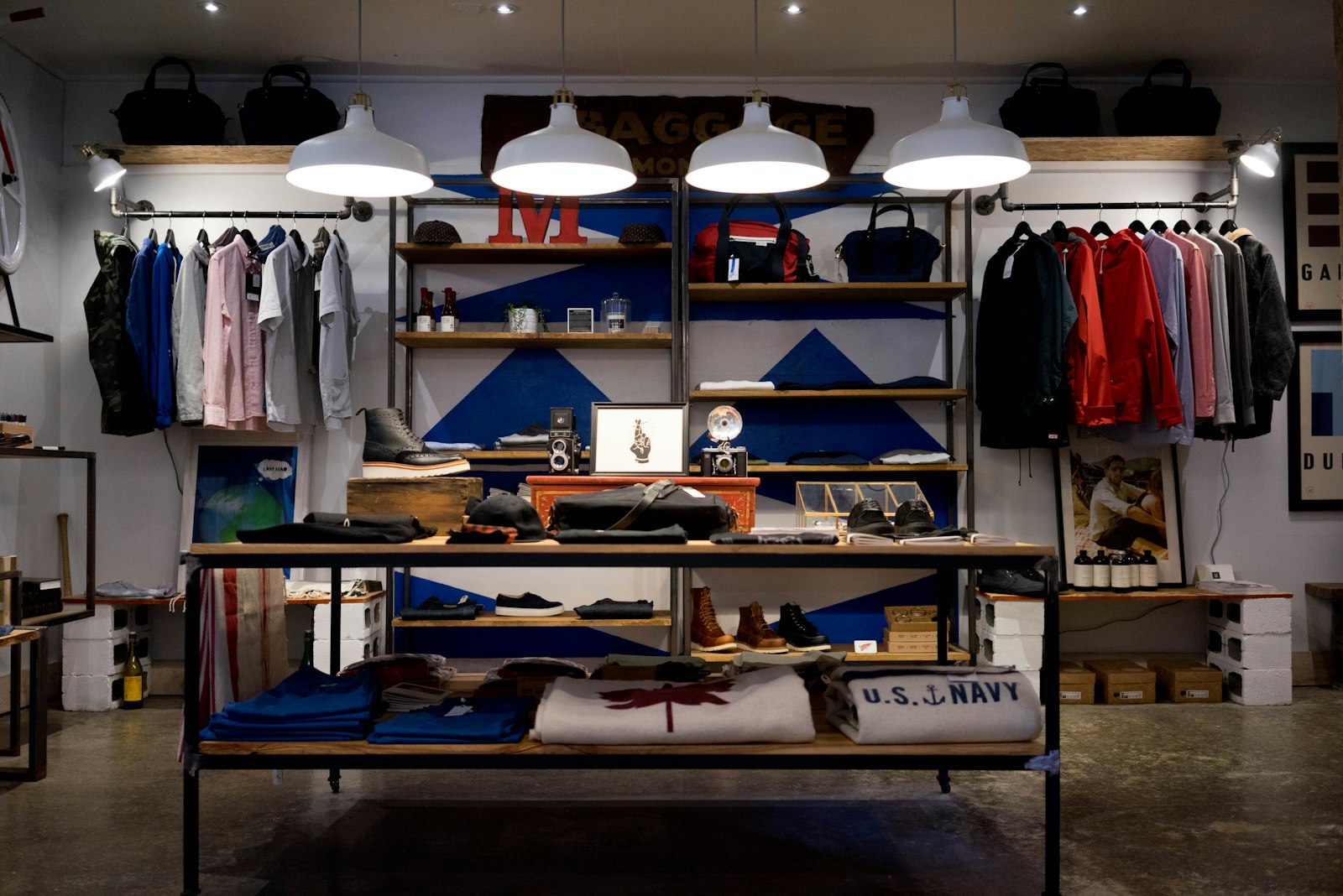 A clothing shop interior with folded shirts, hanging jackets, shelves, and pendant lights. It accompanies an article about Adding AI without turning the product into a chat box.